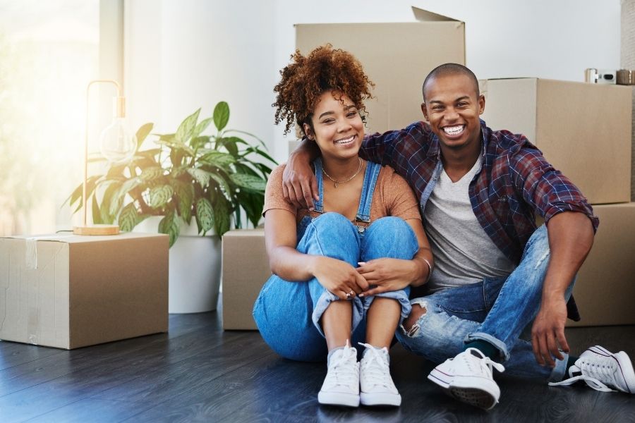young couple sitting in front of moving boxes