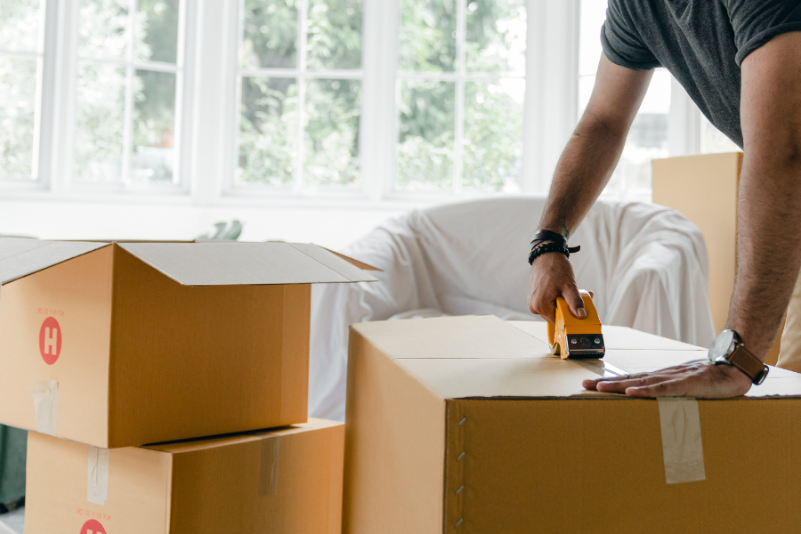 man taping moving boxes