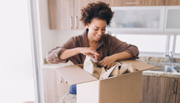 Woman unpacking cardboard box.