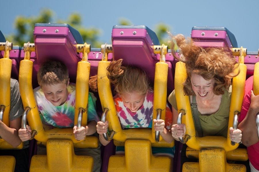 Farmily riding rollercoaster at amusement park. 