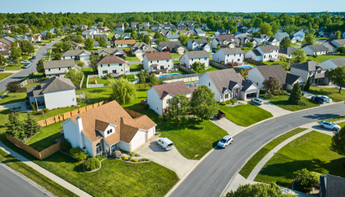 Aerial view of thriving neighborhood with single-family homes and green grass.