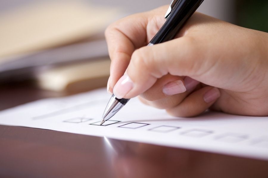 woman signing a VA home loan checklist