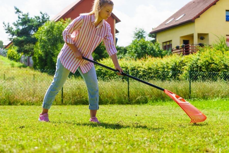 woman using rake to clear yard for for sale by owner