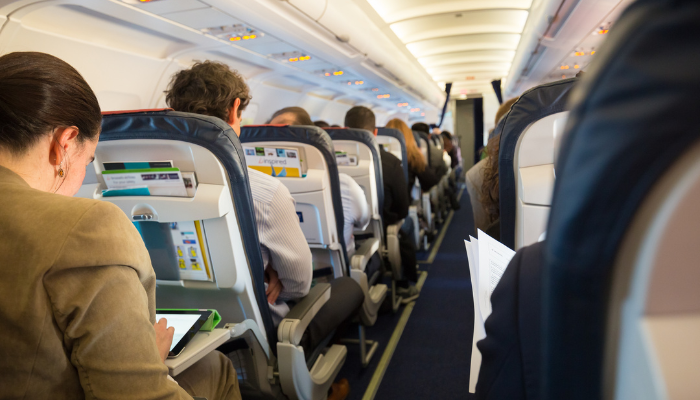 Photo from inside a commercial airplane with people in seats.