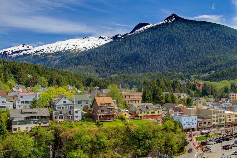 Ketchikan AK homes in wooded valley with mountain, snow, and blue sky