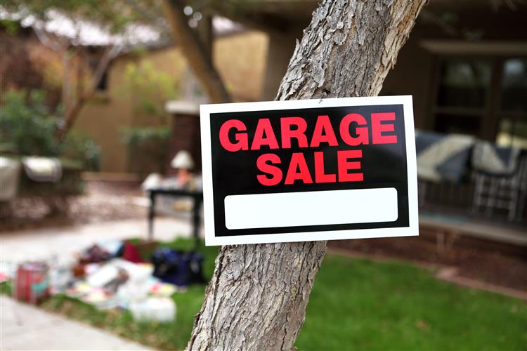garage sale sign tacked to tree