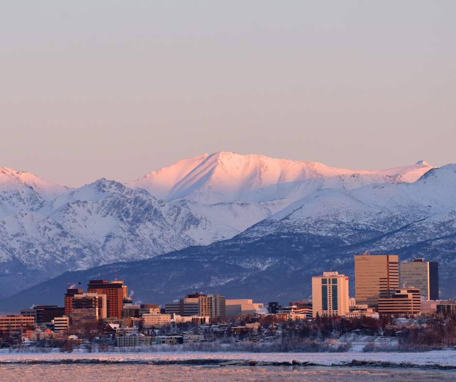 downtown Anchorage Alaska, city skyline with towering snow topped mountains