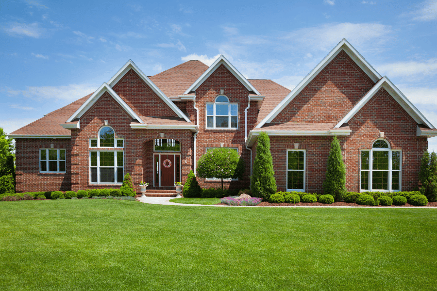 two story brick home with landscaped yard