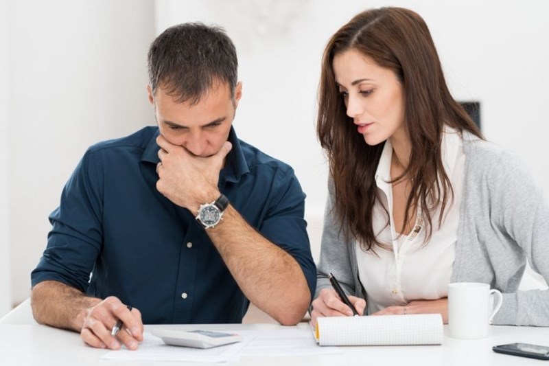 man and woman with calculator and papers 