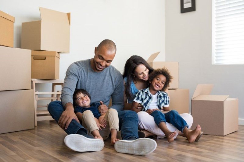 military family with moving boxes in home