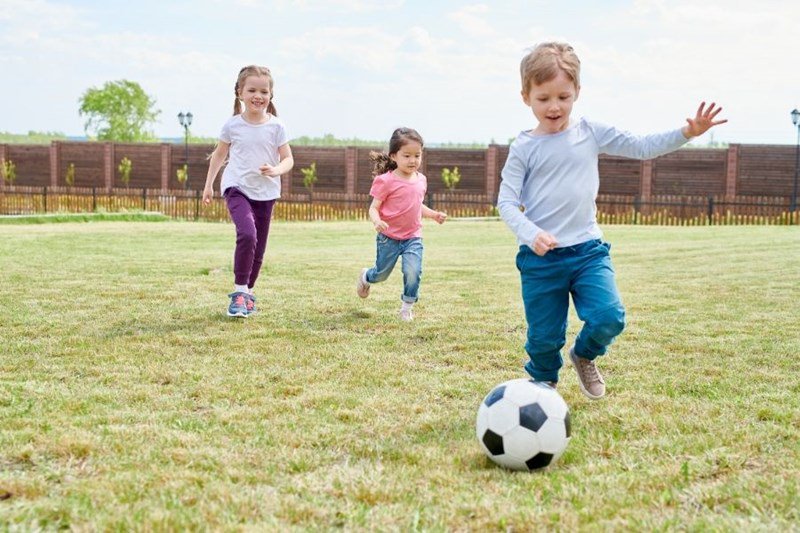 family playing in yard with soccer ball