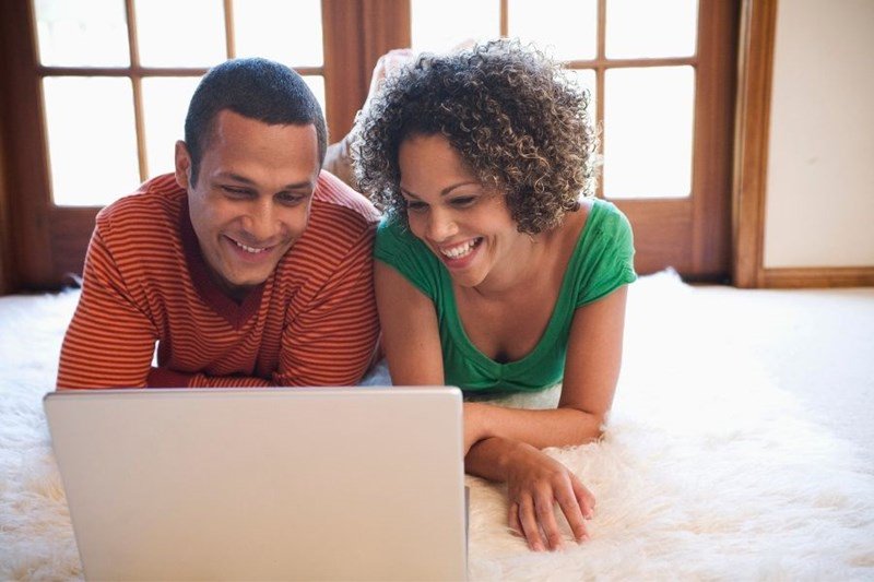 couple looking at home listings on laptop