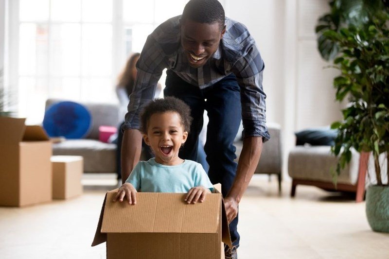 military homeowner pushing child in moving box