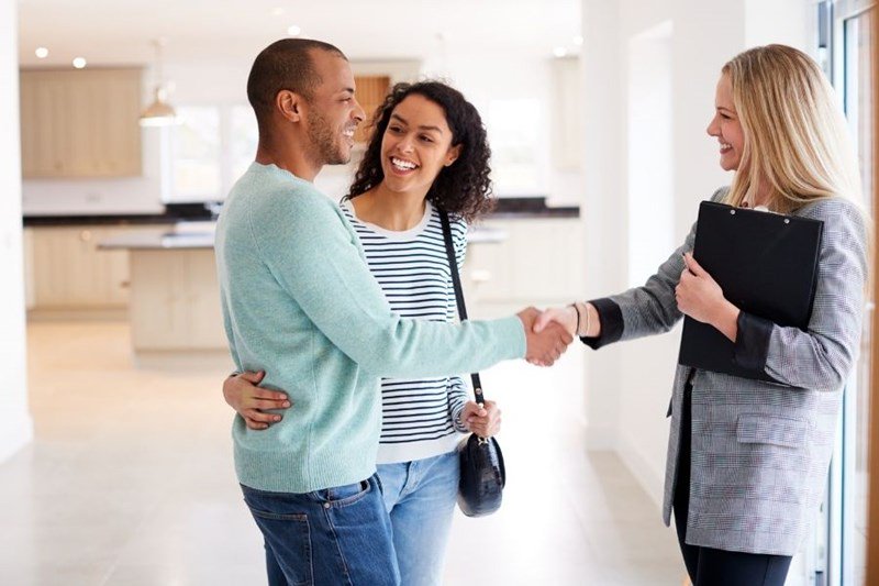real_estate_agent shaking hands with young couple