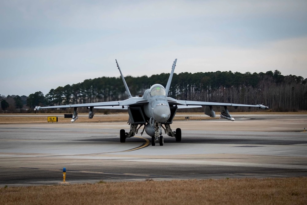 plane taking off from runway at NAS Oceana Virginia with treeline in distance