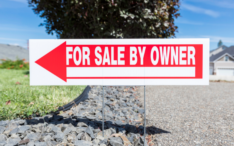 For Sale by Owner arrow sign in ground.