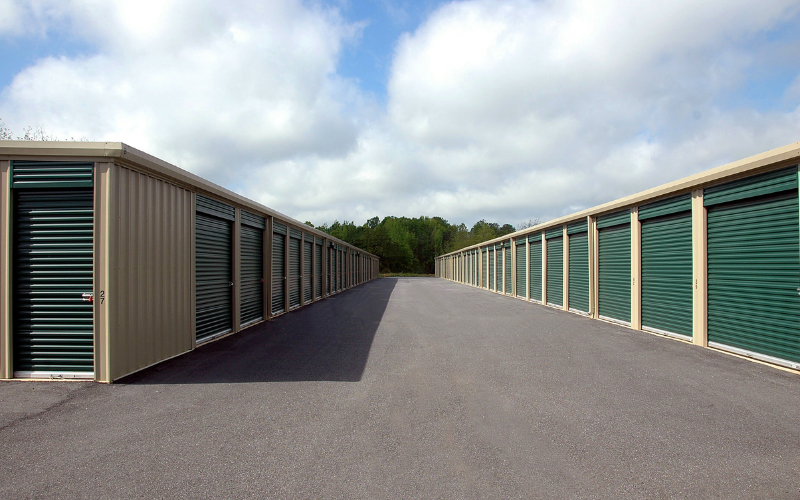 Row of storage units with green doors.
