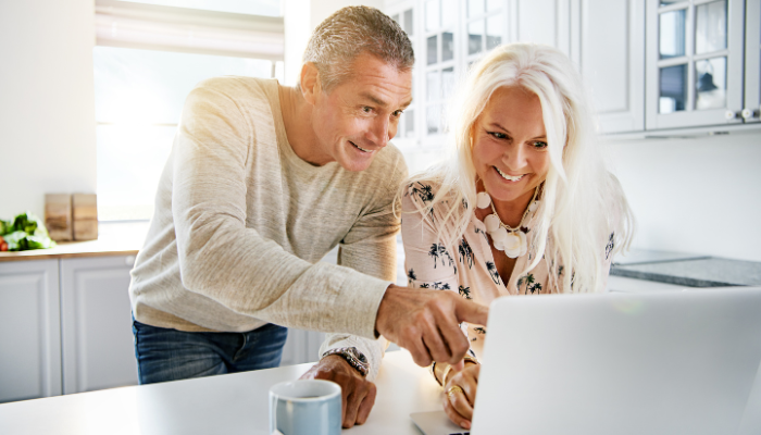 Retired military couple looking for a home to buy on the computer. 