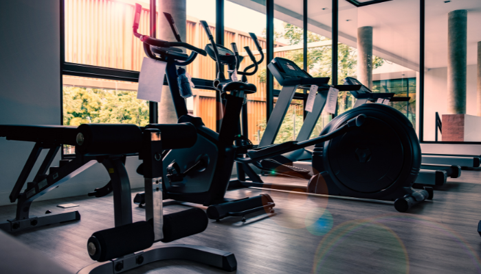 Exercise room with ellipticals and treadmills in front windows.
