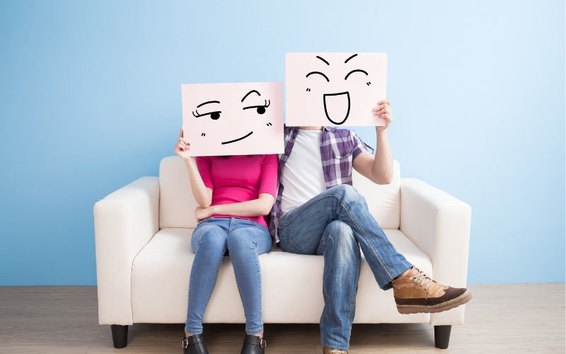 couple with face signs sitting on couch