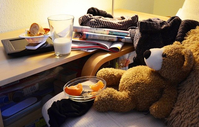 cluttered child's room with teddy bear and desk