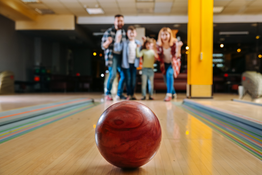 family in bowling alley with bowling ball