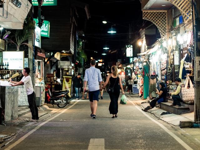 couple walking down city street at night
