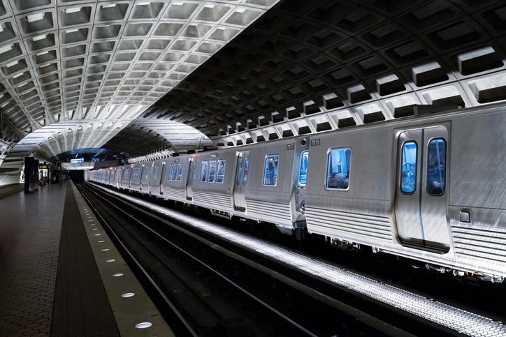 View of underground DC metro station with few people in sight.