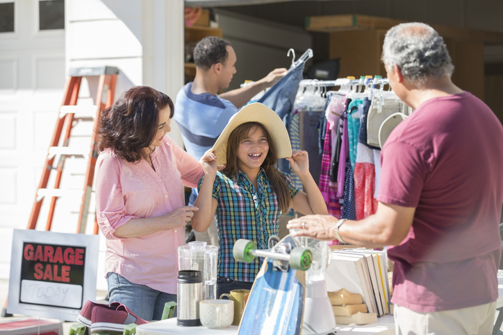 people smiling and looking at items in garage sale