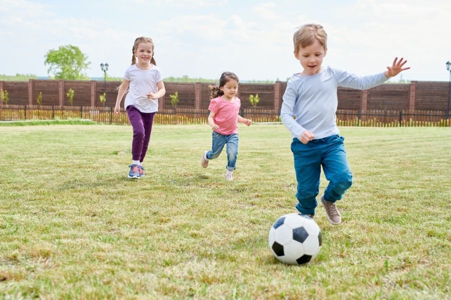children playing in back yard with soccer ball