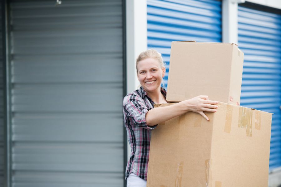 woman carrying boxes out of storage area